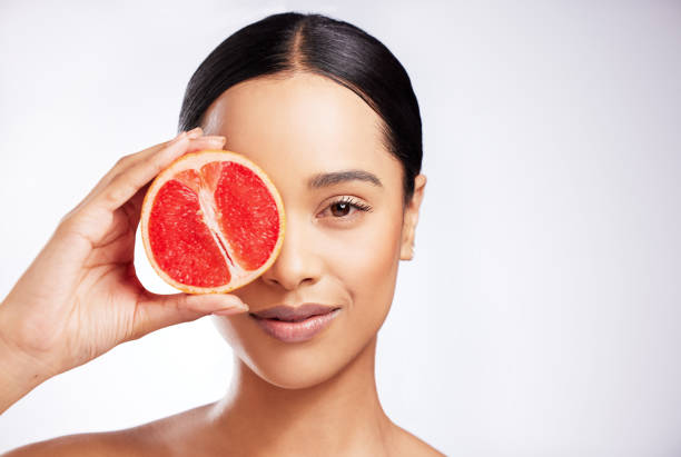 Studio portrait of a beautiful young woman posing with a grapefruit against a white background Natural skincare works best for me A Glowing Skin Diet stock pictures, royalty-free photos & images