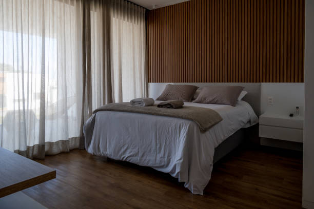 istock Bedroom with double bed, wooden floor and large window 1344838114