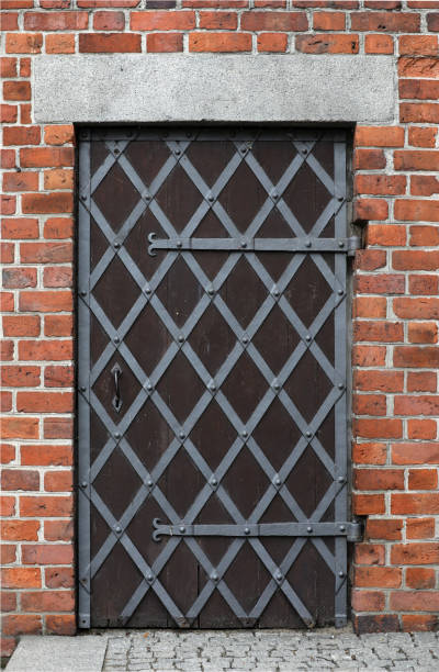 istock Old doors with bars on a background of red brick 1344839079