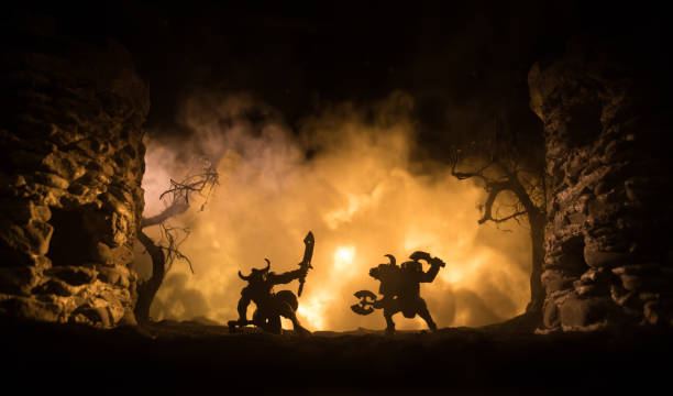 Medieval battle scene with cavalry and infantry. Silhouettes of figures as separate objects, fight between warriors on dark toned foggy background with medieval castle. Medieval battle scene with cavalry and infantry. Silhouettes of figures as separate objects, fight between warriors on dark toned foggy background with medieval castle. Selective focus minotaur photos stock pictures, royalty-free photos & images