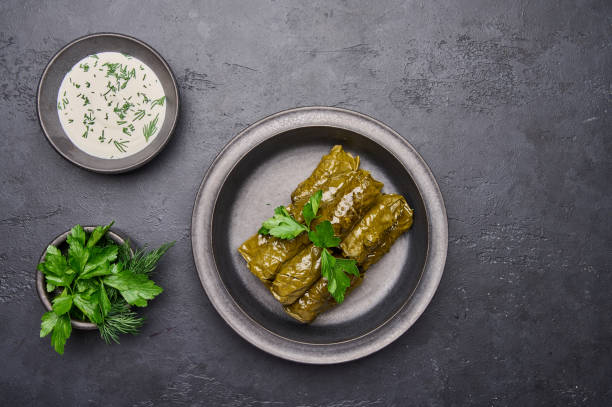 istock Top view dolma, parsley, saucepan with sour cream on ceramic color graphite plate 1344844680