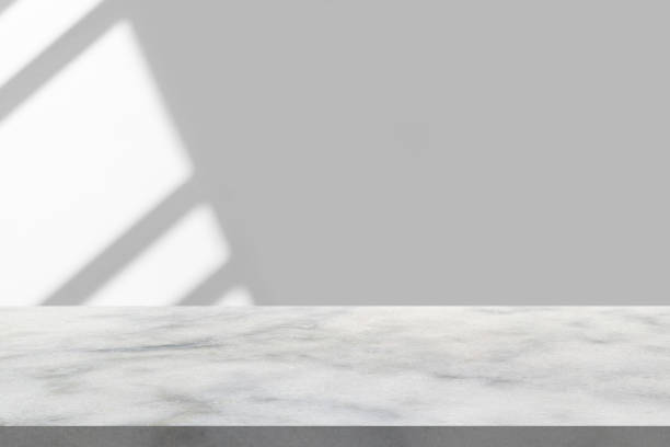 istock Marble table with window shadow drop on white wall background for mockup product display 1344850329