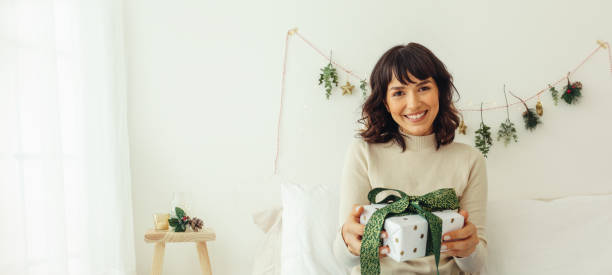 istock Woman at home with a christmas gift 1344850743