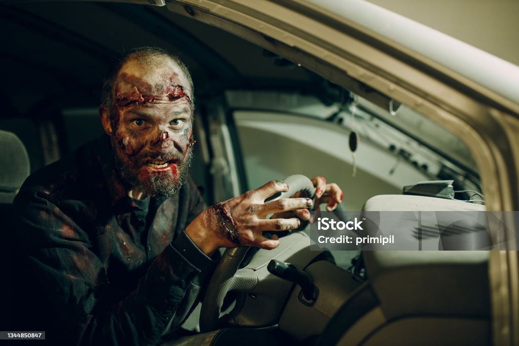 Zombie male makeup for halloween concept. Blood on skin face Zombie driving car to halloween party concept. Make up skin and blood face Zombie Stock Photo