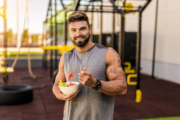 istock Happy young bodybuilder eating a vegetable salad. 1344852947