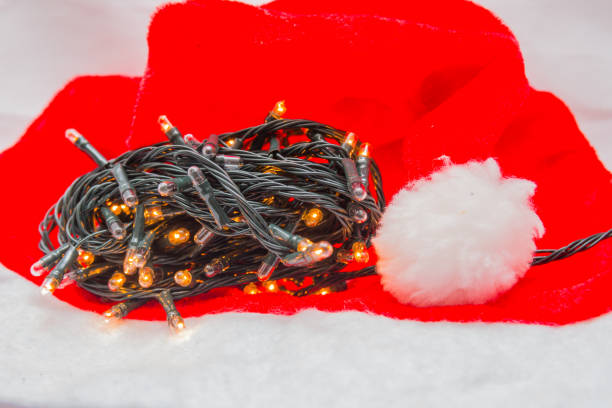 istock Christmas decorative lights with a red hat on a white background 1344853738