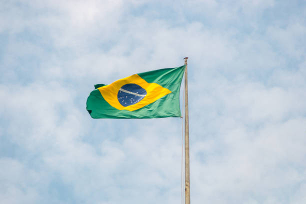 istock brazil flag outdoors with a beautiful blue sky 1344854482