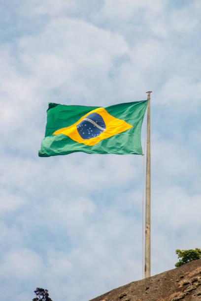 istock brazil flag outdoors with a beautiful blue sky 1344854543