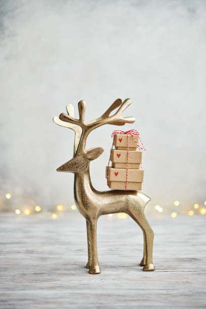 Cute Gold Deer Carrying Gift Stack on Light Gray Background for Christmas