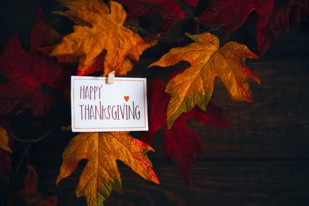 istock Fall Leaves with HAPPY THANKSGIVING Message on Rustic Wood Background 1344859724