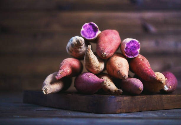 Collection of Sweet Potato Varieties on Rustic Chopping Board