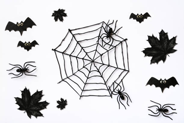 istock Halloween pattern with black maple leaves, spiders and bats on white background 1344860655