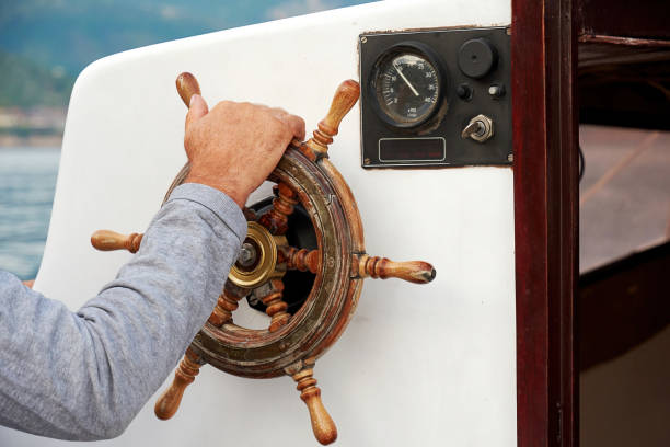 istock The captain's hand steers the ship helm 1344862251
