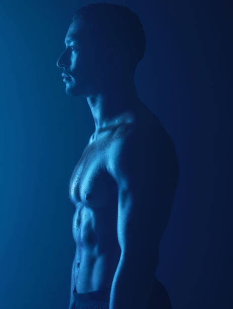 plan de studio d’un jeune homme en forme posant sur un fond sombre - abdominal muscle muscular build men torso photos et images de collection
