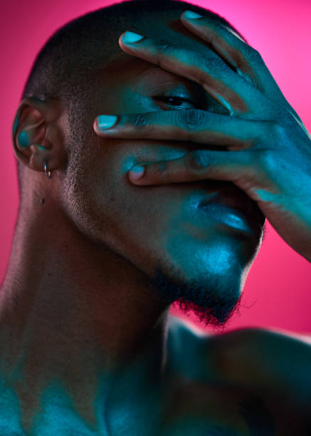 Studio shot of a handsome young man posing against a pink background
