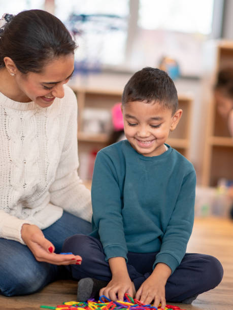istock Daycare Teacher and Young Boy Playing Together 1344864110