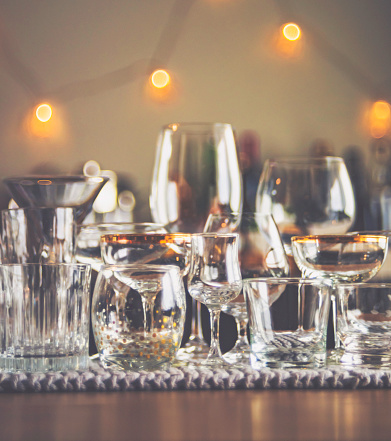 Collection of Empty Wine and Spirit Glasses in Dining Room with Defocused Bar in Background