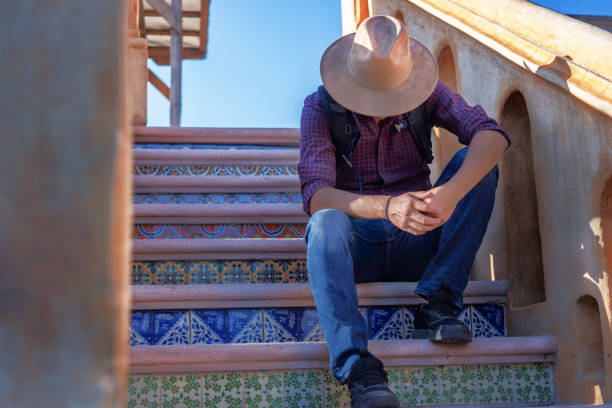 man sitting on ladder with hat