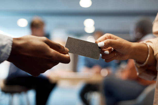 foto de dos empresarios intercambiando tarjetas de visita en una conferencia - tarjeta de negocios fotografías e imágenes de stock