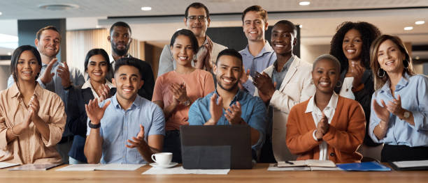 aufnahme einer gruppe junger geschäftsleute, die während einer konferenz in einem modernen büro klatschen - training business seminar clapping stock-fotos und bilder