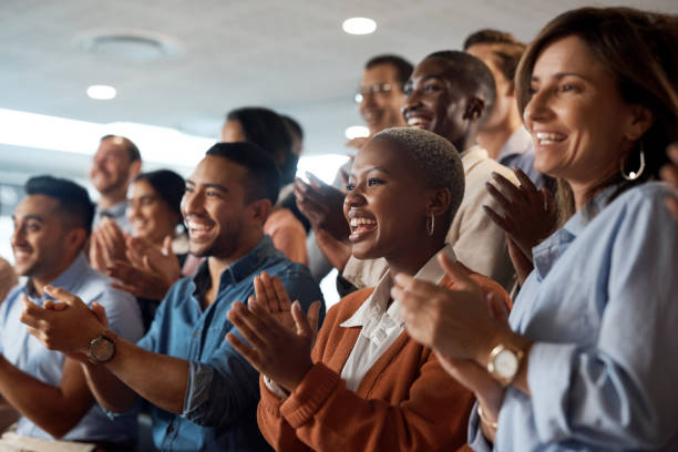 foto de un grupo de jóvenes empresarios aplaudiendo durante una conferencia en una oficina moderna - aplaudir fotografías e imágenes de stock