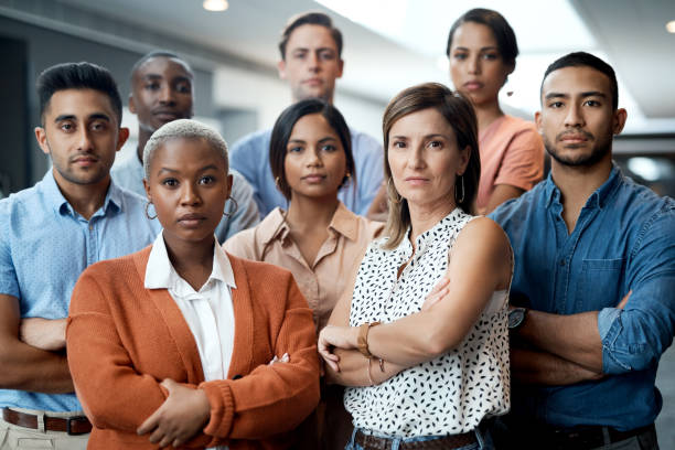 portrait of a group of confident young businesspeople working together in a modern office - blank expression imagens e fotografias de stock