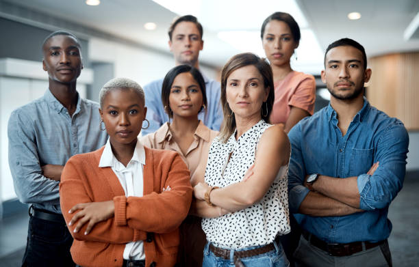 Portrait of a group of confident young businesspeople working together in a modern office The right time is right now arms crossed stock pictures, royalty-free photos & images