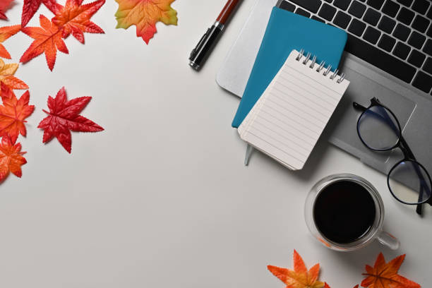 istock Top view laptop computer, coffee cup, glasses, notebook and maple leaves on white background. 1344878954