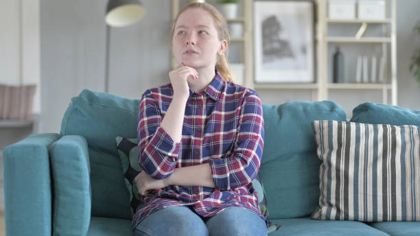 istock Relaxing Young Woman Sitting on Couch 1344882340