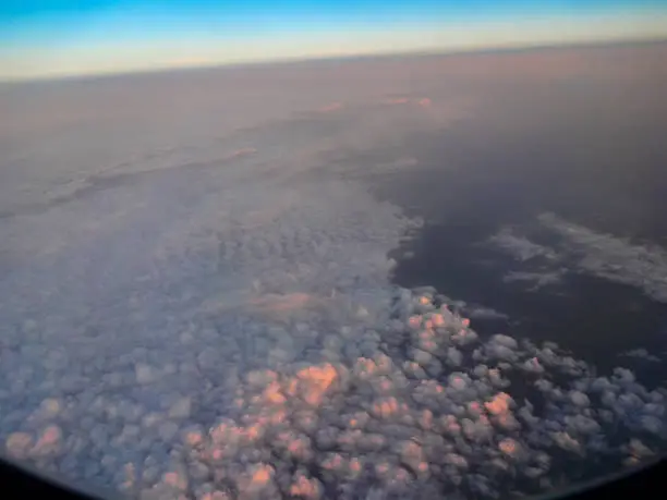 View of the clouds from the plane's window - clouds in the first rays of the sun