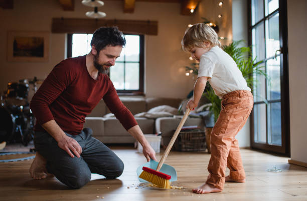 istock Father with small son sweeping at home, daily chores concept. 1344882741