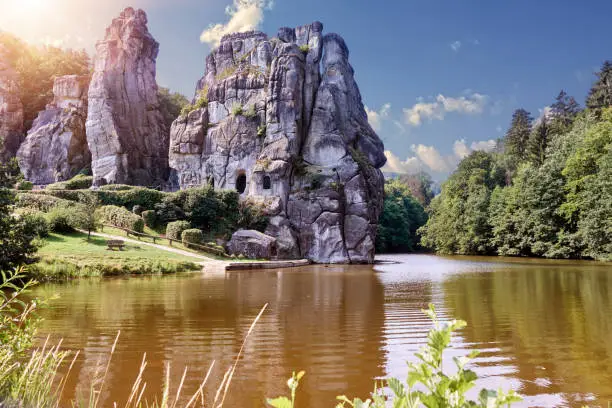 Pond in front of the rock formation of the Externsteine in the back light