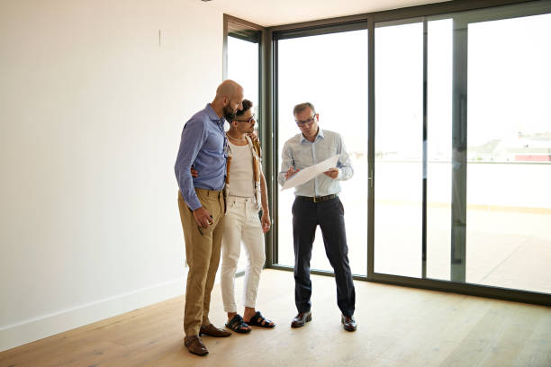 istock Real Estate Agent Discussing Floor Plan with Gay Couple 1344886177