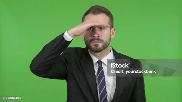 Ambitious Businessman Trying To Look Far Off Against Chroma Key Stock Photo - Download Image Now