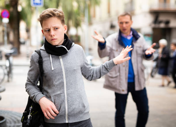 istock Frowning teenager gesturing enough while man reprimanding him 1344891699
