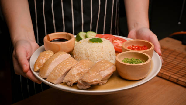 imagen de un plato de cocina asiática. una camarera sirve arroz de pollo hainanés - isla de hainan fotografías e imágenes de stock