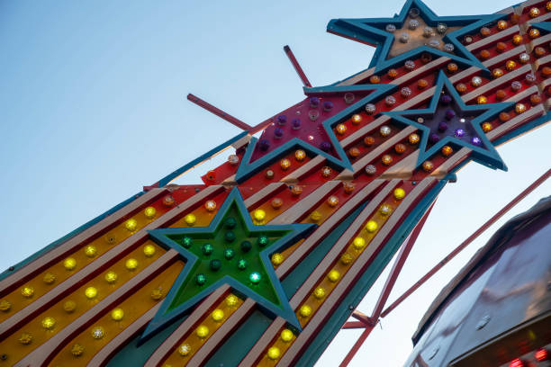 istock Colorful retro electric light display on old amusement park carnival ride with broken star 1344897508