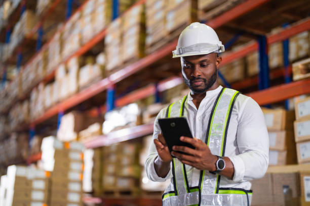 Warehouse worker working process checking the package with a tablet in a large distribution center stock photo