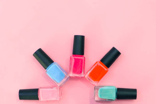 istock multicolored nail polishes on a pink background. 1344899590
