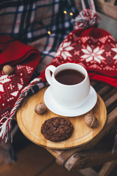 istock Tea and cookie with festive lights on terrace. 1344900559