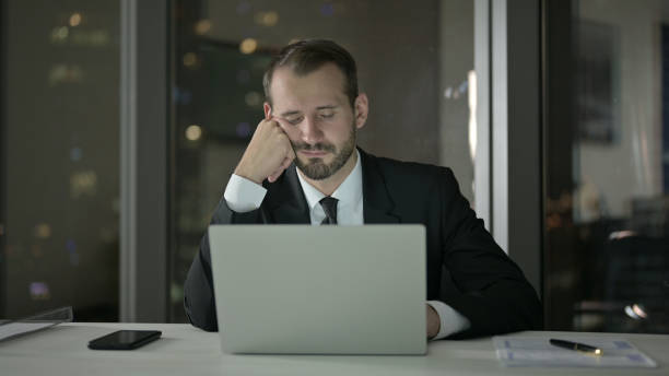 istock Tired Businessman having Nap at Office table at Night 1344900569