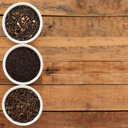 Top view of three bowls with varieties of loose teas (Jasmine, english breakfast and oolong)