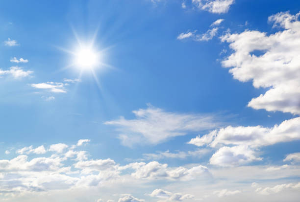 istock Bright sun with beams on sky with light fluffy clouds soft focus. 1344902097