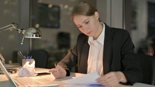 istock Young Businesswoman working on Documents in Office at Night 1344902419