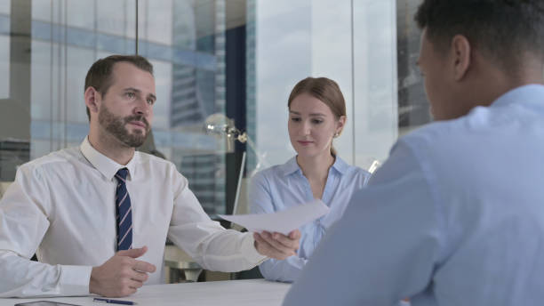 istock Rear Back View of Man getting Documents from Business people 1344903698