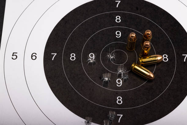 .45 balas de pistola en el fondo del objetivo de papel de ojo de buey - gun rounds fotografías e imágenes de stock