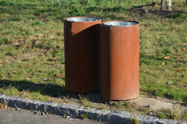 istock stainless steel with a surface rusty oxidized layer of rust. in the square in the park are these metal trash cans. two next to each other, due to higher collection capacity 1344905139