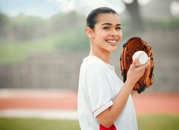 istock Cropped portrait of an attractive young female baseball player standing outside while wearing a mitt and holding a baseball 1344907607