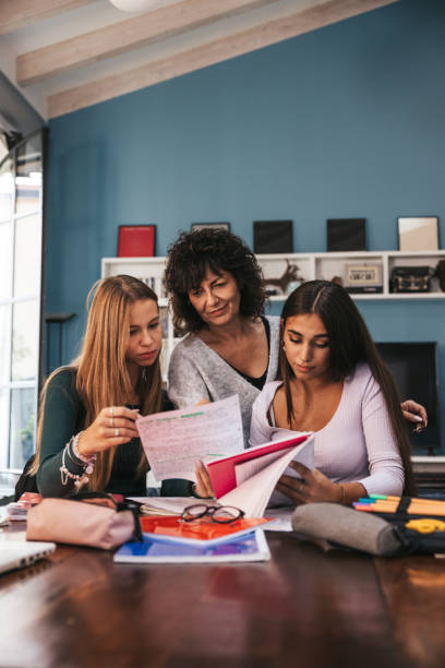 istock Mother helping her daughter to study on a research and homework 1344913331