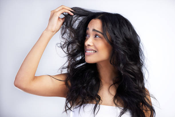 Shot of an attractive young woman standing alone in the studio and feeling stressed while posing with messy hair Why aren't you cooperating with me? frizzy stock pictures, royalty-free photos & images